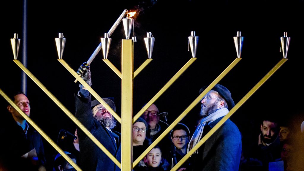 Mensen met Joodse geloof vieren Chanoeka met kaarsjes en lichtjes - Wat Is Het Joodse Geloof