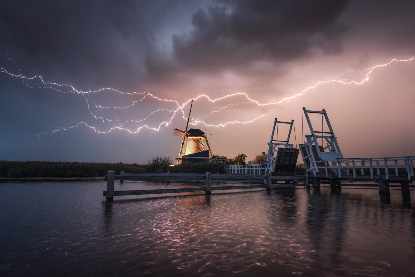Onweer en bliksem verlichten de hemel boven Kinderdijkse molens | Foto - Hoeveel Tellen Tussen Bliksem En Donder